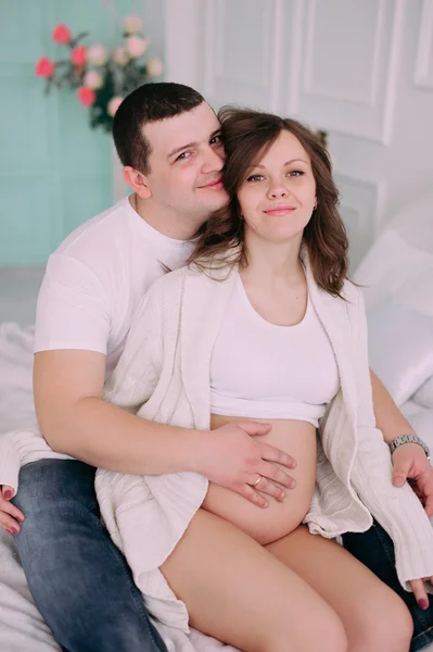 Family waiting for baby's birth. A pregnant woman and her husband wearing white clothing — Stock Photo, Image