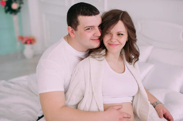 Family waiting for baby\'s birth. A pregnant woman and her husband wearing white clothing