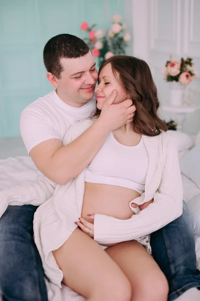 Familie wachten op de geboorte van baby. Een zwangere vrouw en haar echtgenoot dragen witte kleding — Stockfoto
