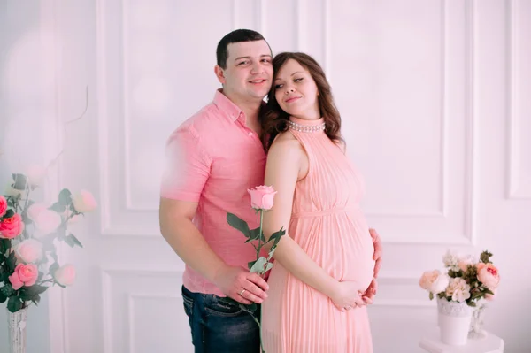 Family waiting for baby\'s birth. A pregnant woman and her husband wearing white clothing