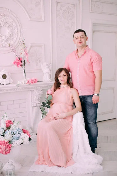 Family waiting for baby\'s birth. A pregnant woman and her husband wearing white clothing