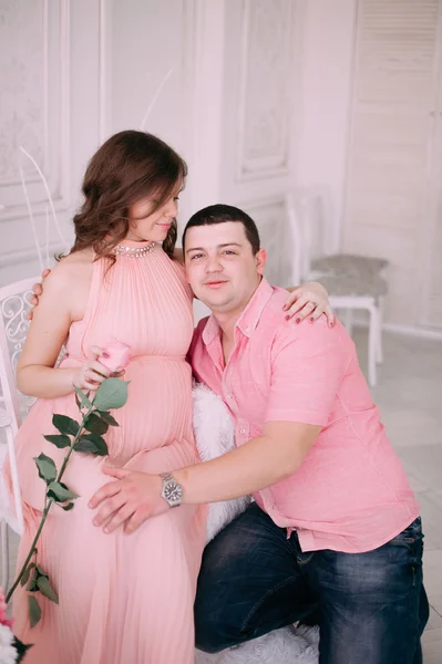 Οικογένεια περιμένοντας την γέννηση του μωρού. Μια έγκυος γυναίκα και ο σύζυγός της φορώντας λευκά ρούχα — Φωτογραφία Αρχείου