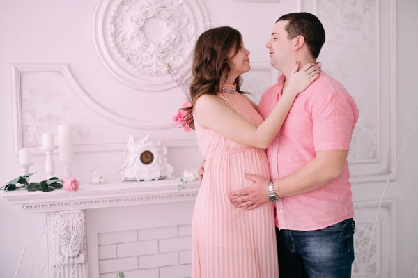 Rodina čeká na narození dítěte. Těhotná žena a její manžel na sobě bílé oblečení — Stock fotografie
