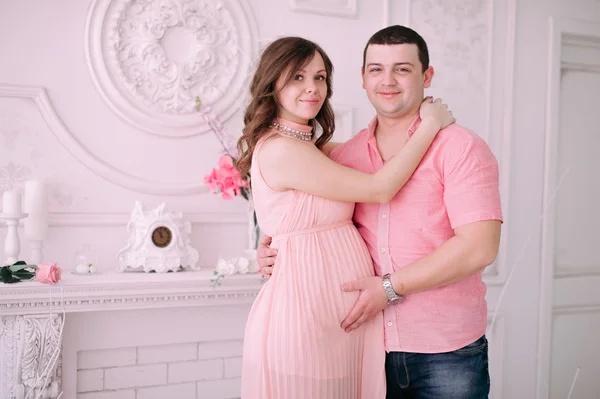 Bebeğin doğumu için bekleyen ailen. Hamile bir kadın ve kocası giyen beyaz giyim — Stok fotoğraf