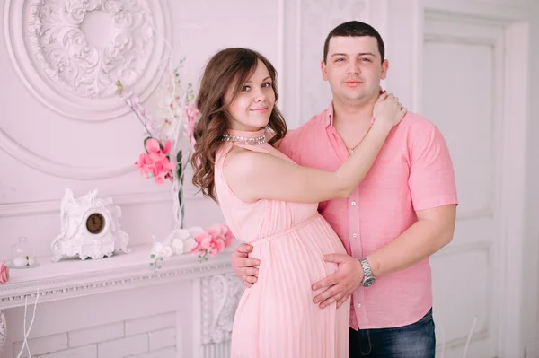 Familjen väntar på förlossningen. En gravid kvinna och hennes man bär vita kläder — Stockfoto