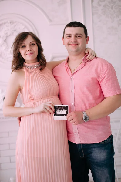Bebeğin doğumu için bekleyen ailen. Hamile bir kadın ve kocası giyen beyaz giyim — Stok fotoğraf