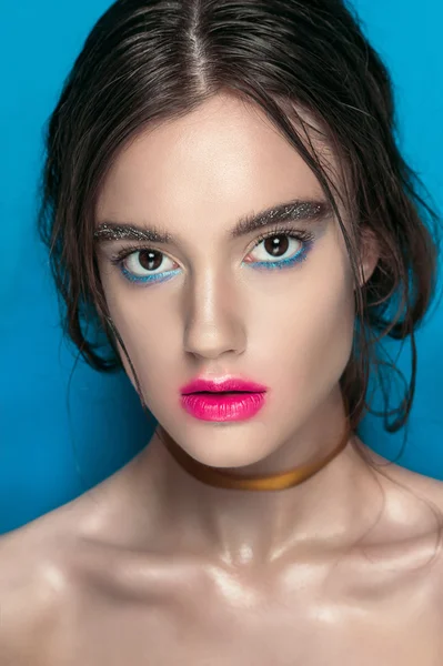 Retrato de chica de belleza con maquillaje vívido. Retrato de mujer de moda de cerca sobre fondo azul. Colores brillantes. Maquillaje de manicura. Ojos humeantes, pestañas largas. Rainbow Colors. Disparo retoque — Foto de Stock