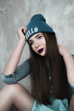 Mavi şapka ve gri elbise sırt çantası ile hipster kadın moda