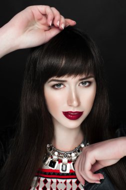 Bir deri ceket ve kırmızı desen elbise giyen bir kadın