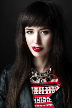 Bir deri ceket ve kırmızı desen elbise giyen bir kadın