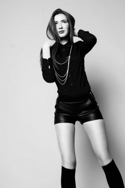 Siyah ve beyaz im oturan genç kız siyah çorap ve şort,