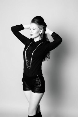 Siyah ve beyaz im oturan genç kız siyah çorap ve şort,