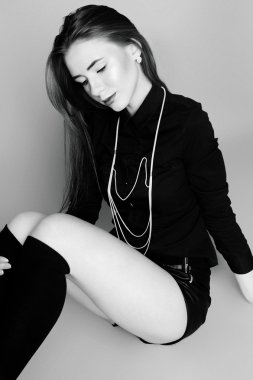 Siyah ve beyaz im oturan genç kız siyah çorap ve şort,