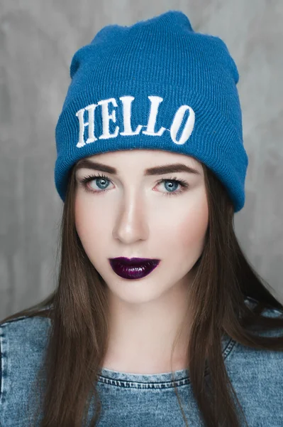 Mode hipster vrouw met rugzak in blauwe hoed en grijze jurk — Stockfoto