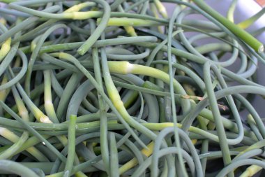 Yığının içinde toplanmış taze sarımsaklı oklar var. 