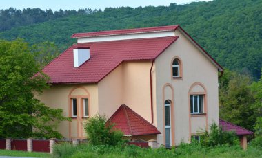 Çatısı metal kiremitlerle kaplı olan ev.