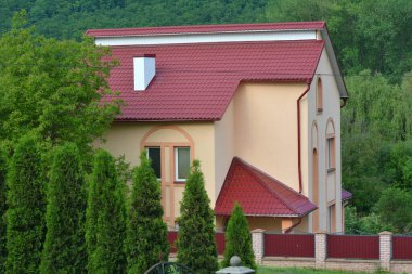 Çatısı metal kiremitlerle kaplı olan ev.