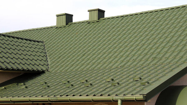 Дом, крыша которого покрыта металлической плиткой