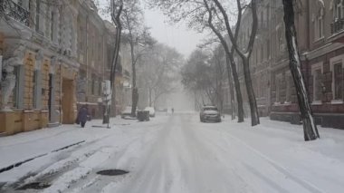 Eski bir Avrupa şehrinin boş bir caddesine kar yağıyor. Kaldırımda tek bir kadın figürü kaldırılıyor. Uzakta, yalnız bir adam caddenin ortasında yürüyor..