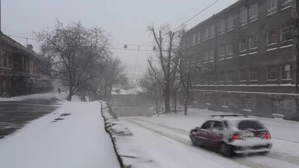 老城区的暴雪一辆被雪覆盖的汽车下坡了 — 图库视频影像