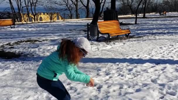 아이들이 눈가지고 공원에서 겨울이었습니다 가벼운 재킷을 선글라스를 소녀가 조각을 가지고 — 비디오