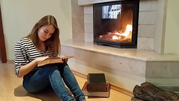 Uma Adolescente Sentada Chão Frente Uma Lareira Está Lendo Livro — Vídeo de Stock