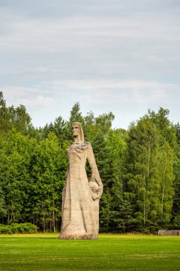 Letonya 'da ağaçlarla çevrili uzun heykel