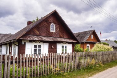 Traditional wooden houses in Dzukija, Lithuania surrounded by greenery
