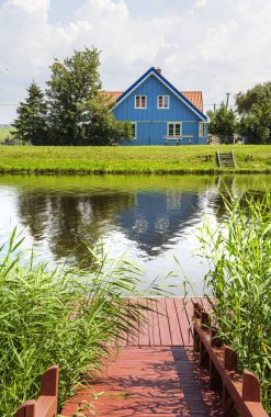 Minija Litvanya 'da durgun suyun yanındaki mavi ev