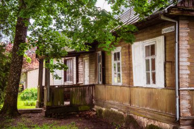 Old wooden house surrounded by trees in Lithuania