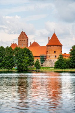 Trakai kalesi ağaçlarla çevrili göle yansıyor.
