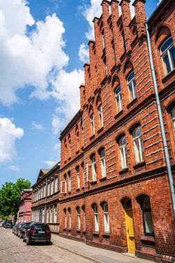 Liepaja 'daki kırmızı tuğla bina mavi gökyüzünün altında.