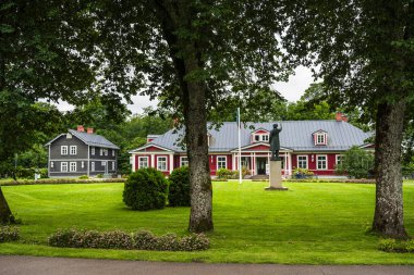 Sigulda 'da ağaçlarla çevrili kırmızı ve gri binalar