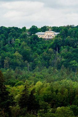 Sigulda 'da yeşil ağaçlarla çevrili bina manzarası