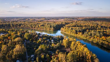 Renkli sonbahar ağaçlarıyla çevrili nehrin havadan görünüşü