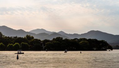 Dağlar ve teknelerle Batı Gölü manzarası