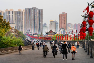 İnsanlar ellerinde fenerlerle Xian şehir duvarında yürüyor.