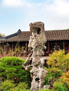 Suzhou Bahçesi 'ndeki kaya oluşumu yeşilliklerle çevrili.