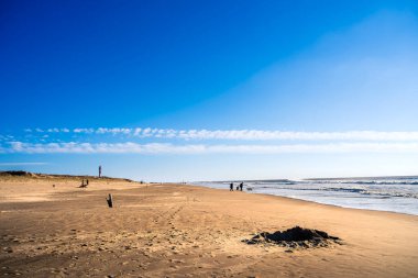 Cote Sauvage 'daki kumsalda yürüyen insanlar.