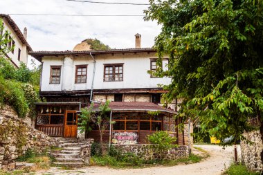 Geleneksel Bulgar evi yeşillik ve ağaçlarla çevrili.