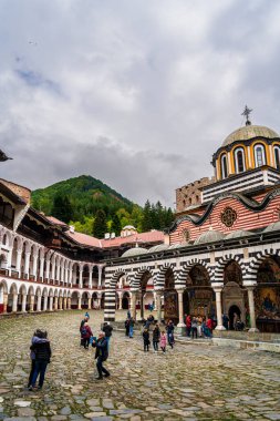 People visiting Rila Monastery courtyard in Bulgaria