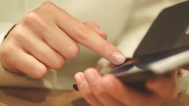 女の子プリントのテキスト電話ダイヤル番号、屋内では、携帯電話の画面にクローズ アップ、指を印刷 — ストック動画