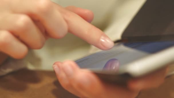 女の子プリントのテキスト電話ダイヤル番号、屋内では、携帯電話の画面にクローズ アップ、指を印刷 — ストック動画