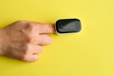 Kan oksijeni seviyesini ölçmek için kadın parmağında nabız oksimetresi kullanılıyor. Boşluğu kopyala.