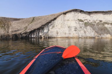 Nehirde kırmızı yük teknesinde kürek çekiyor. Seçici odaklanma. Etkin yaşam konsepti.