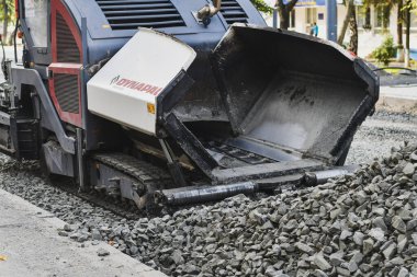 Yol yapımında çalışan asfalt kaldırım makinesini kapatın. Seçici odak.