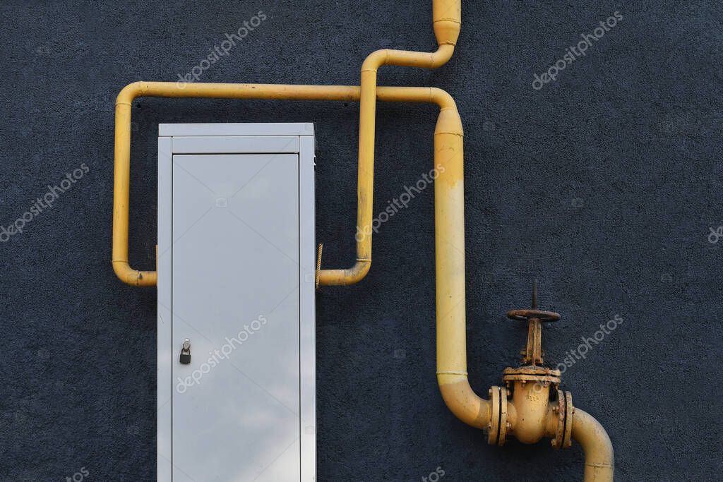 Caja de contadores de gas con tuberías sobre fondo gris grunge. Equipo