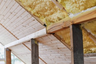 Tavan arası yalıtımı, ahşap çatının altında köpük püskürtme. Seçici odak.