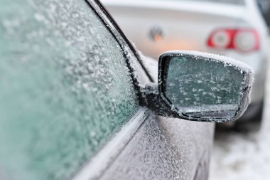 Donmuş araba aynası kışın ağır buz ve buzla kaplı. Seçici odak.