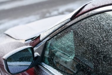 Park halindeki arabayı soğuk bir sabahta buzdan ve buzdan korumak için kış camı kapağı.